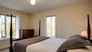 A bedroom with a four-poster bed, a dresser, and two windows. - Family Time in Love, Virginia: Mountain Cabin Getaway (Love)
