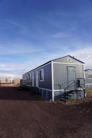 A single-story mobile home with a front porch and a small attached garage. - Quiet Escape Studio Perfect for Exploring Natural Wonders in Williams, Arizona (Williams)