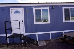 A small building with a white door, a window, and a picnic table outside. - Quiet Escape Studio Perfect for Exploring Natural Wonders in Williams, Arizona (Williams)