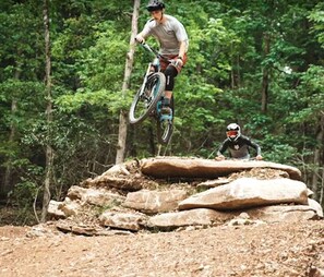 A mountain biking trail with natural terrain and trees.