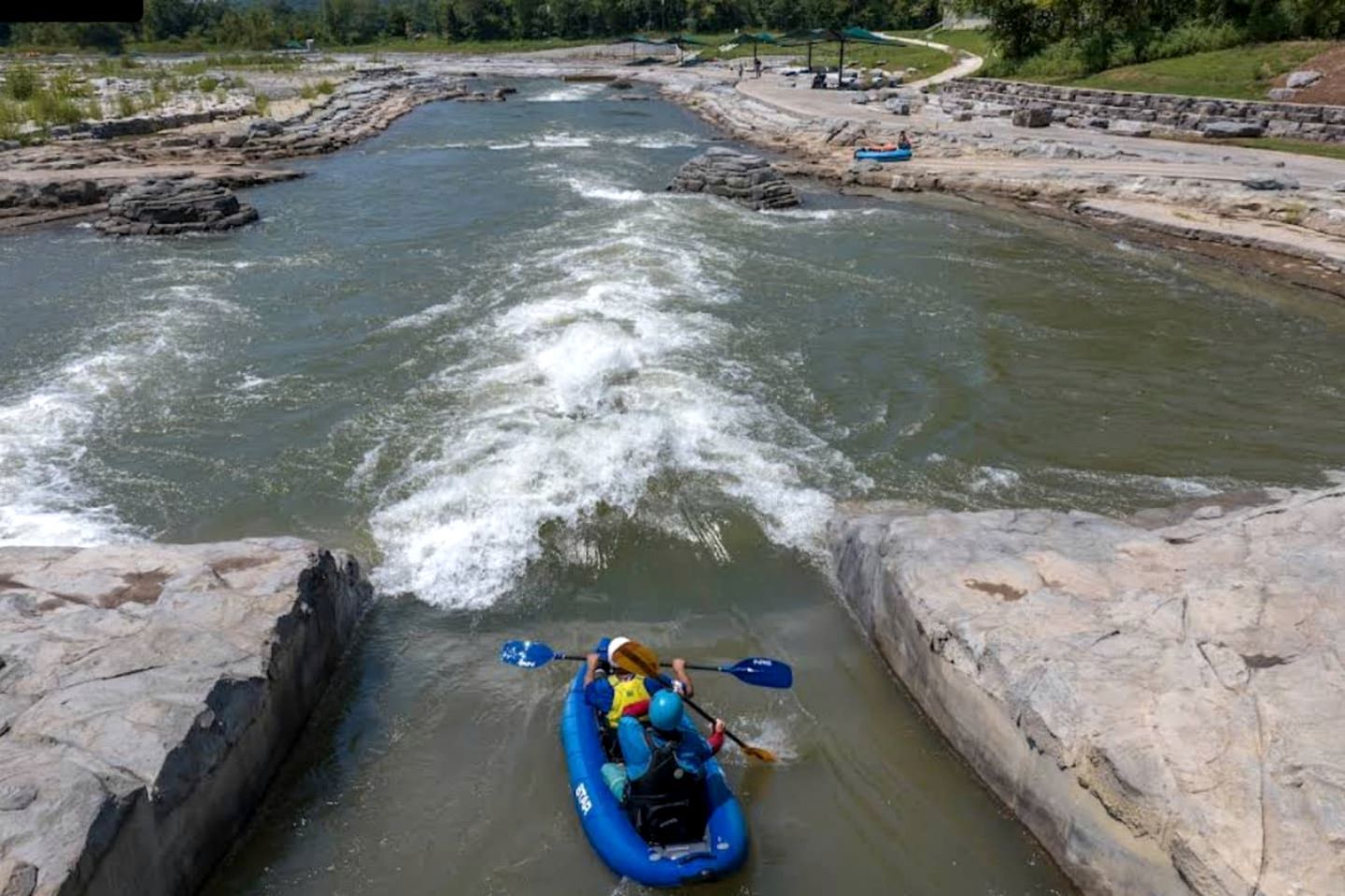 Ein Fluss, auf dem eine Person Kajak fährt.