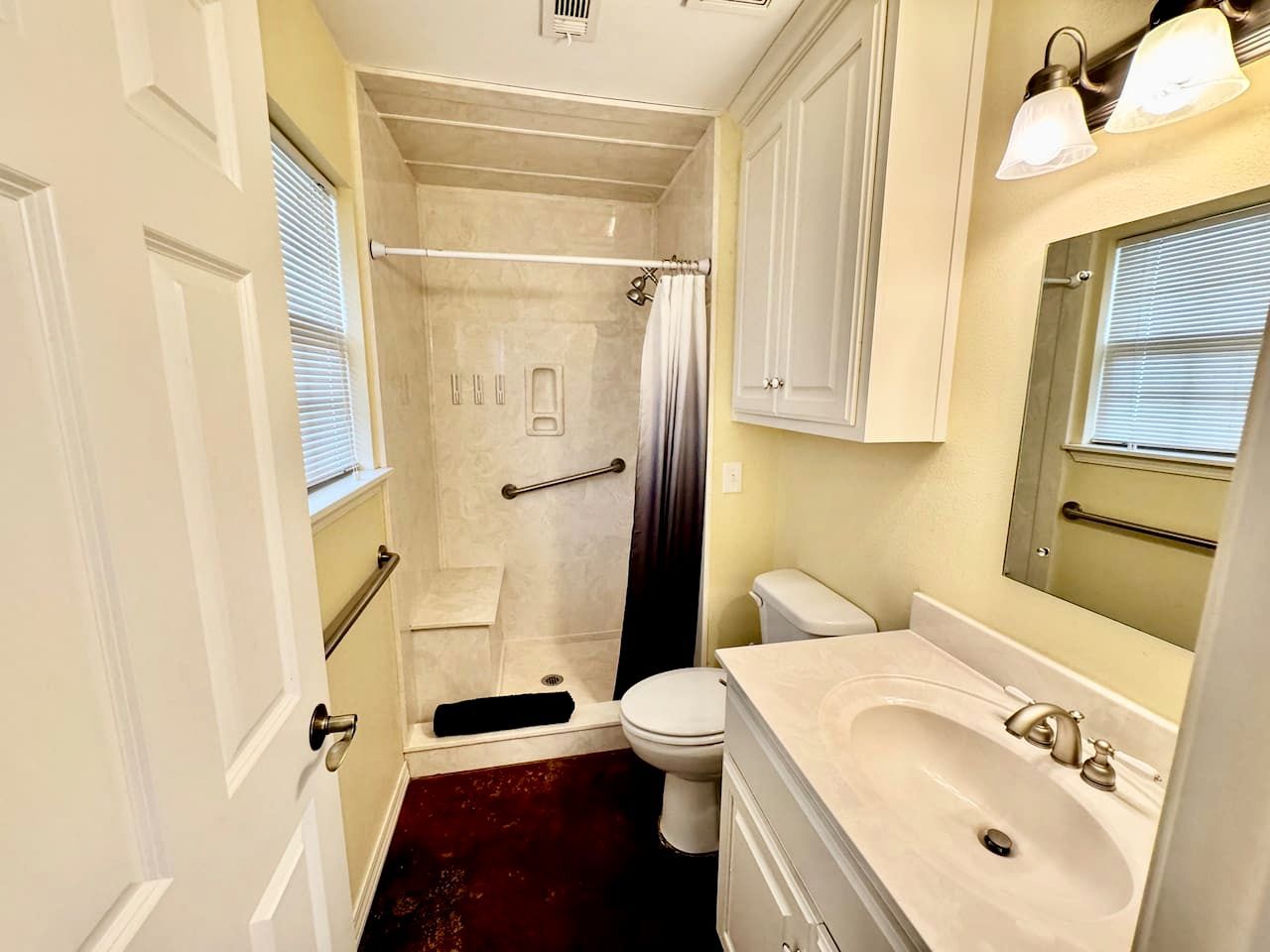 Une salle de bain équipée d’une douche, de toilettes, d’un lavabo et d’un miroir.