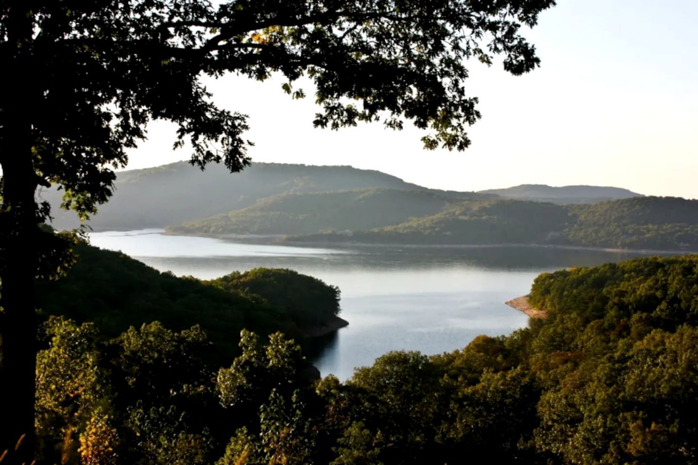 Un lac entouré de collines boisées.