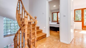 Un escalier en bois menant à une chambre dotée d’une fenêtre.