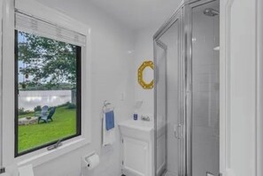 Une salle de bain avec une fenĂȘtre, une douche et des toilettes.