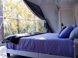 Quarto com uma cama, janela e porta.