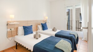 Ein Hotelzimmer mit zwei Betten, einem Balkon und Blick ins Freie.