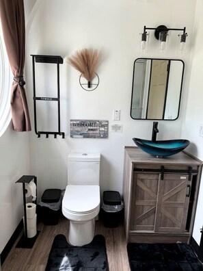 Un bany modern amb vàter, bidet, pirona amb rentapel i mirall.
