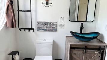 Ein modernes Badezimmer mit Toilette, Bidet, Waschtisch und Spiegel.
