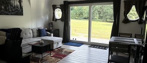 A living room with a sofa, coffee table, and a dining area with chairs and a table.