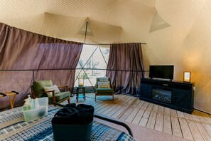 A tent-style room with a television, seating area, and a fireplace.