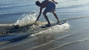 A person surfing on a beach with mountains in the background. - Spacious Pet-Friendly Safari Tent on Yuba Lake with Spectacular Views for a Memorable Glamping Escape in Utah (Levan)