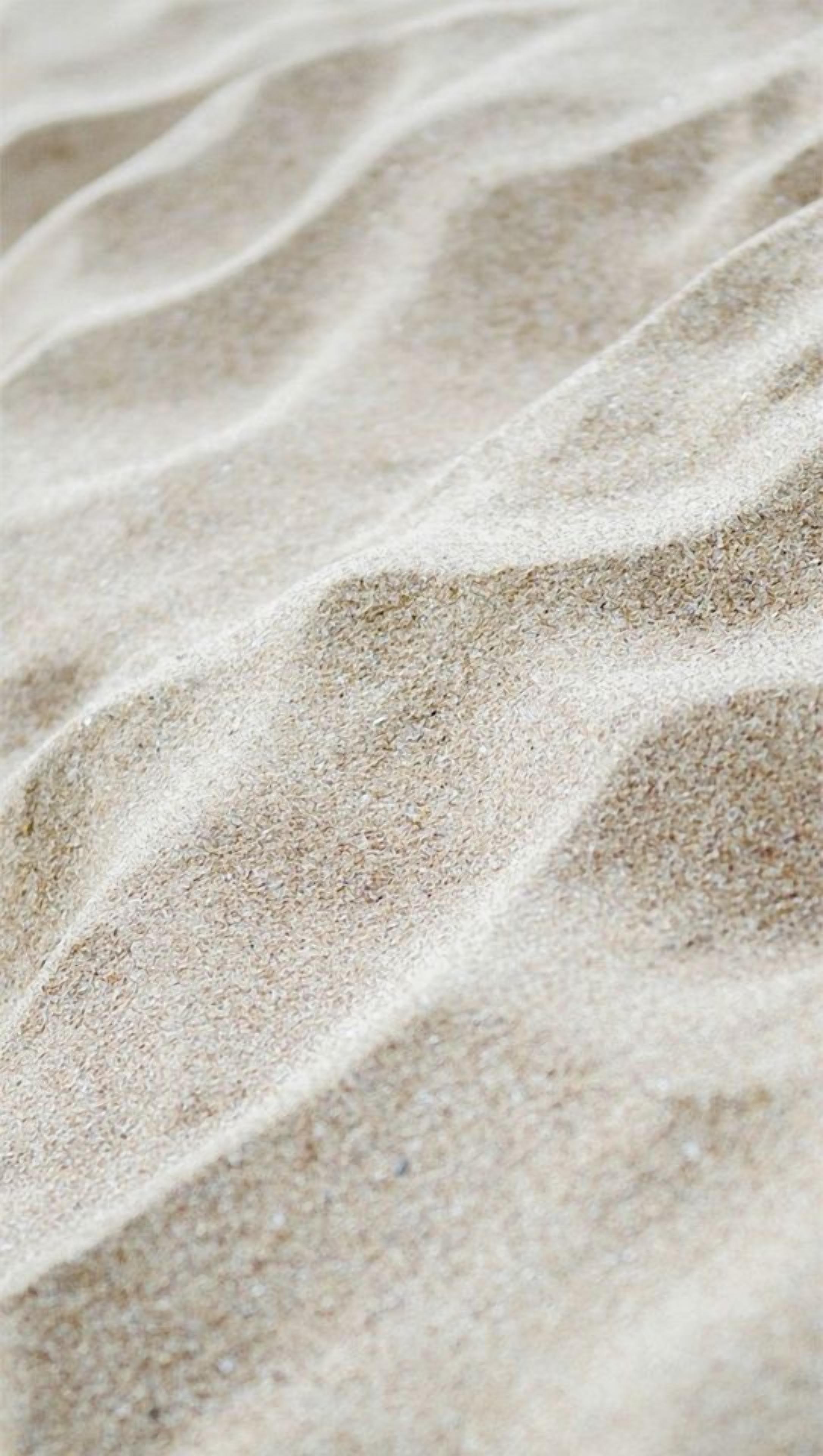 A close-up of sand with ripples.