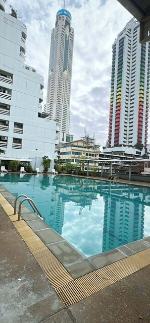 A swimming pool with a view of tall buildings, including a distinctive blue and white tower. - DEN - A2 Pratunam - Juldis Tower (Bangkok)