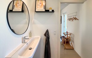 Ein Badezimmer mit Waschbecken, Spiegel und Handtuchhalter.