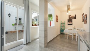 Et moderne køkken med spiseplads, en skydedør til en balkon og en hængende plante.