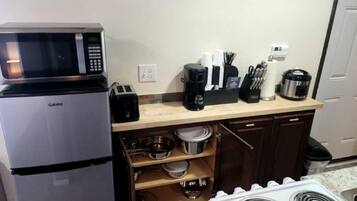 A compact kitchen with a Galanz microwave, a coffee maker, a toaster, and a stove.