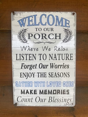 Un cartel de bienvenida con texto que invita a relajarse, disfrutar de la naturaleza y crear recuerdos.