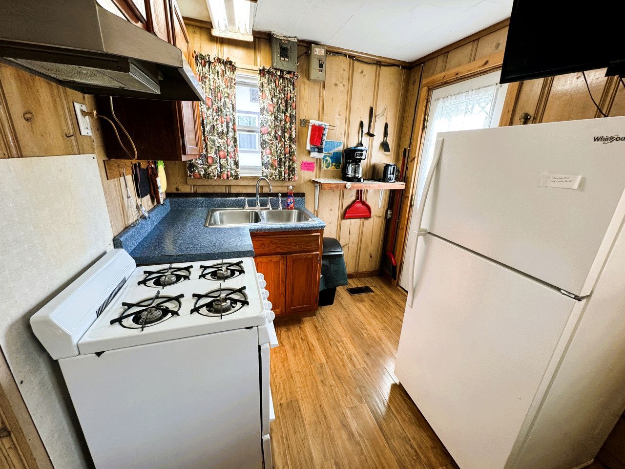 A compact kitchen with a gas stove, sink, and a refrigerator.