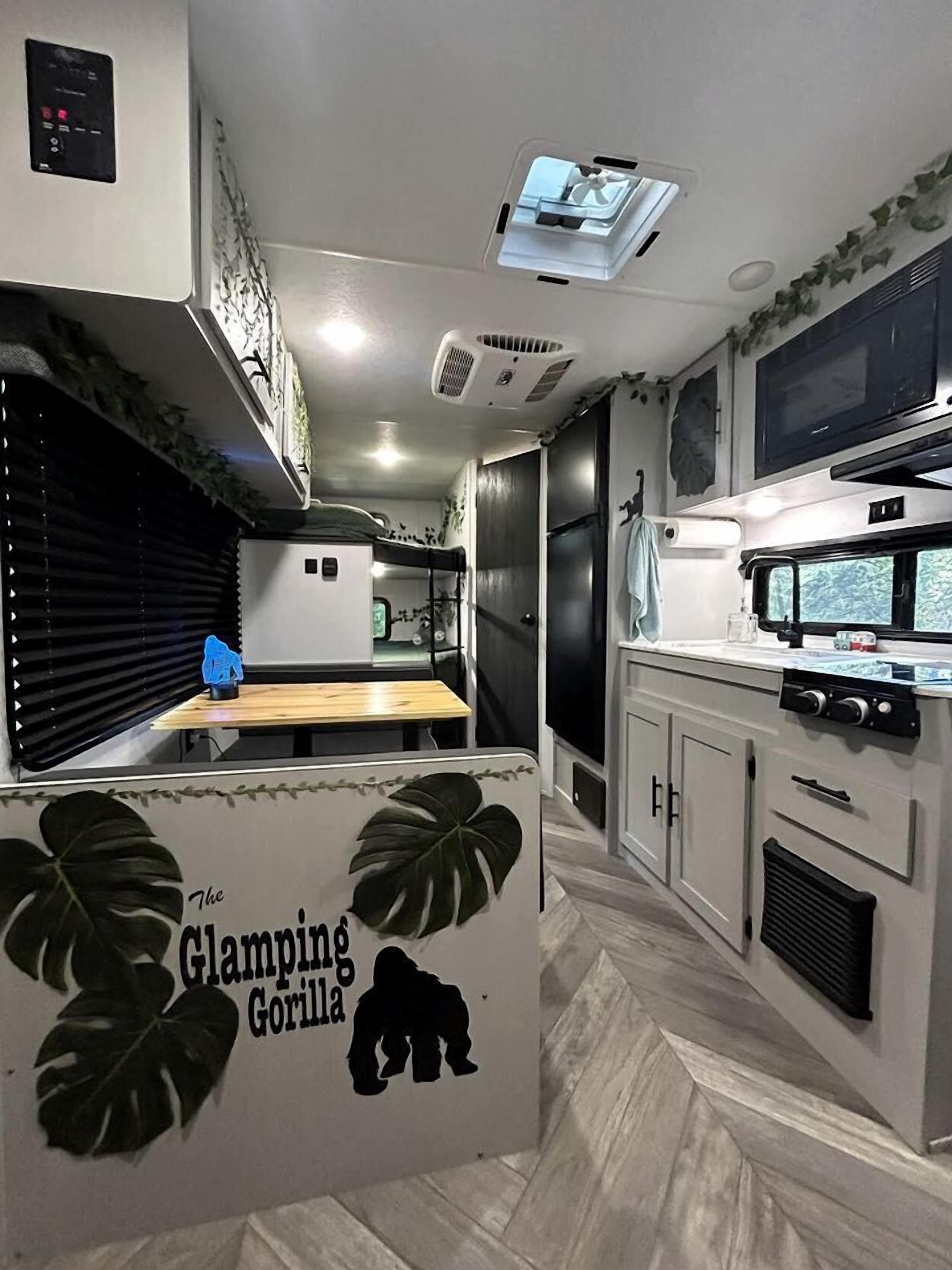 Una cocina compacta equipada con microondas, estufa y una pequeña mesa de comedor.
