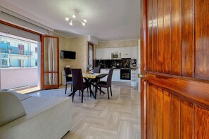 Una cocina moderna con armarios blancos, un microondas y una zona de comedor con mesa y sillas.