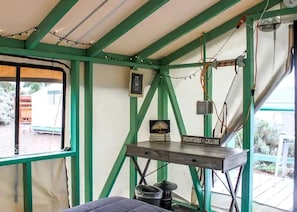 A tent-like structure with a table, a sign, and some electrical wiring.