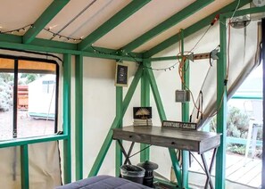A tent-like structure with a table, a sign, and some electrical wiring.