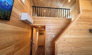 A wooden interior with a staircase leading to a balcony. - Modern Chalet Escape with Sunset Views & Private Porch in Williams, Arizona (Williams)