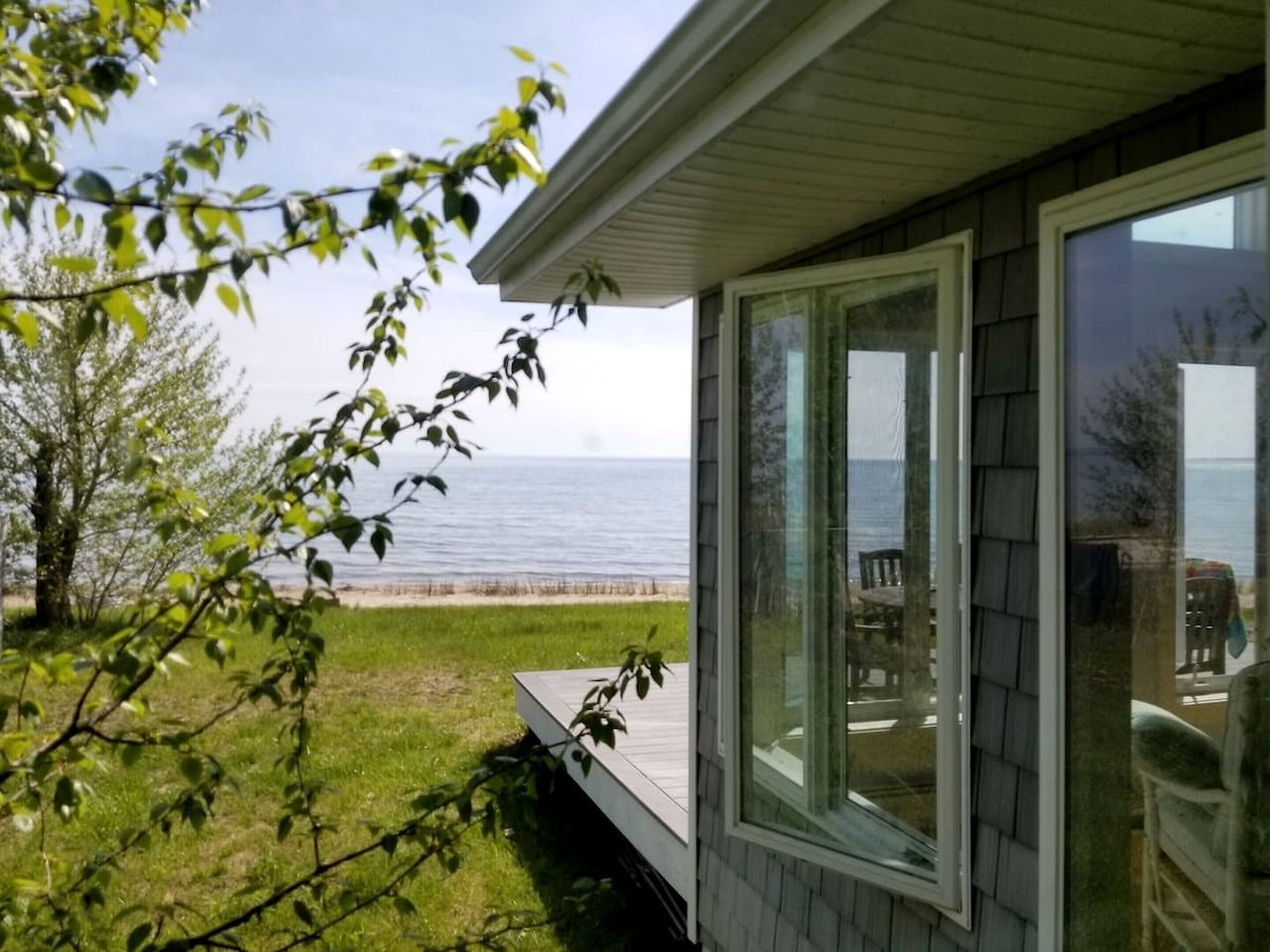 A house with a deck overlooking a beach.