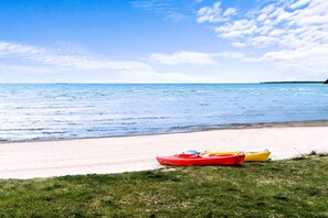A beach with kayaks and a clear sky. - Beautiful Lakefront Cottage with Fire Pit in St. Ignace, Michigan (St. Ignace)