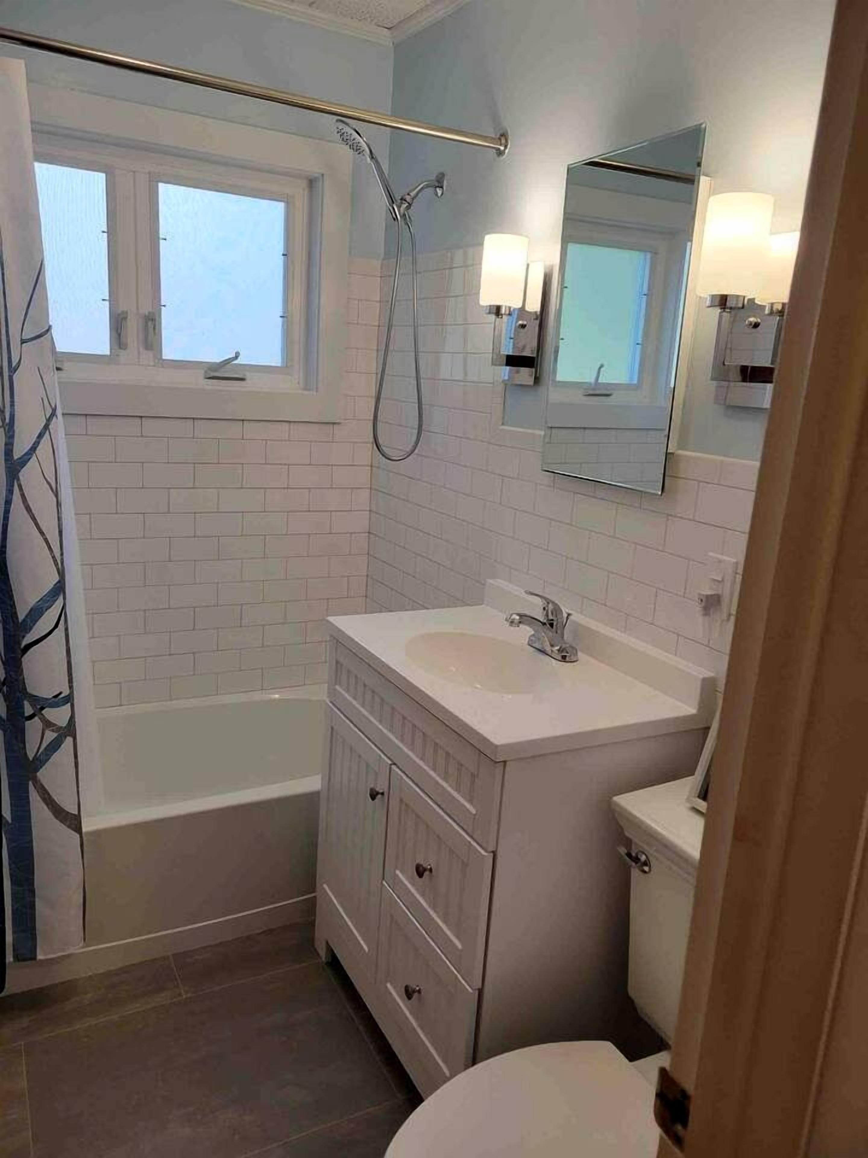 A bathroom with a bathtub, a toilet, a sink, and a shower.