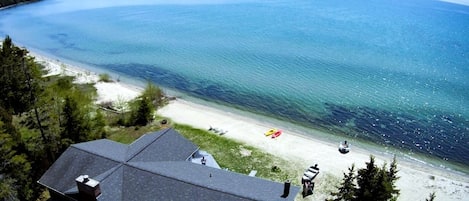 Una propiedad costera con una casa grande, una playa y vista al mar.