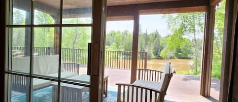 A wooden deck with outdoor seating and a view of a natural landscape.