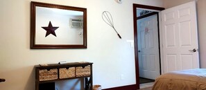 A room with a star decoration, a whisk, and a door leading to another room.