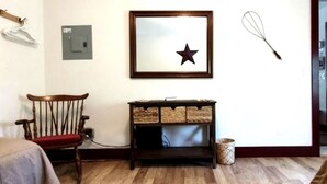 A room with a wooden chair, a framed star decoration, a whisk, and a door. - Handicapped Accessible Log Cabin Rental near Smugglers' Notch Park, Vermont (Hyde Park)