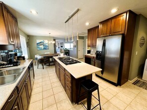 Una cocina con una isla central, electrodomésticos de acero inoxidable y armarios de madera.