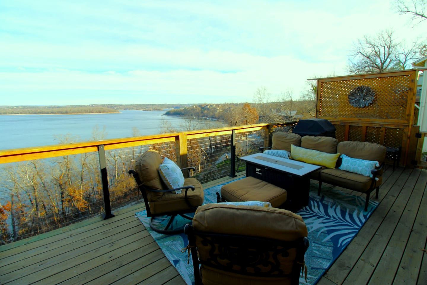 Une terrasse dotée de mobilier d’extérieur, d’une table et offrant une vue sur un plan d’eau.
