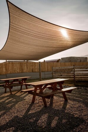 A shaded picnic area with wooden benches and a large canopy. - Adventure-Ready A-Frame Cabins with Fire Pit & Cozy Mountain Setting in Emigrant, Montana (Emigrant)