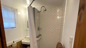 Ein kleines Badezimmer mit Toilette, Waschbecken und Duschbereich.