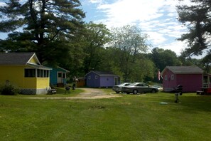 A campground with several small cabins, a gravel path, and parked cars. - Lakefront Cottage Rental near Bear Brook State Park in Northwood, New Hampshire (Northwood)