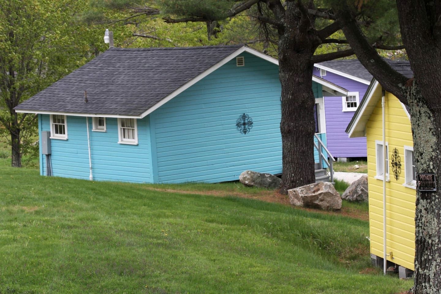 A small, single-story house with a sloped roof, a front porch, and a visible chimney.