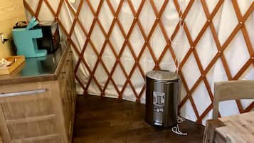 A room with a wooden desk, a trash can, and a partition wall.