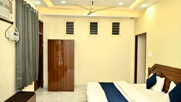 Ein Schlafzimmer mit Bett, Deckenventilator, Kleiderschrank und einem Fenster mit Jalousien.