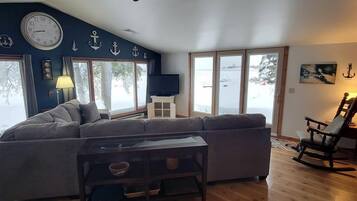A living room with a ceiling fan, a sofa, a coffee table, and a rocking chair.