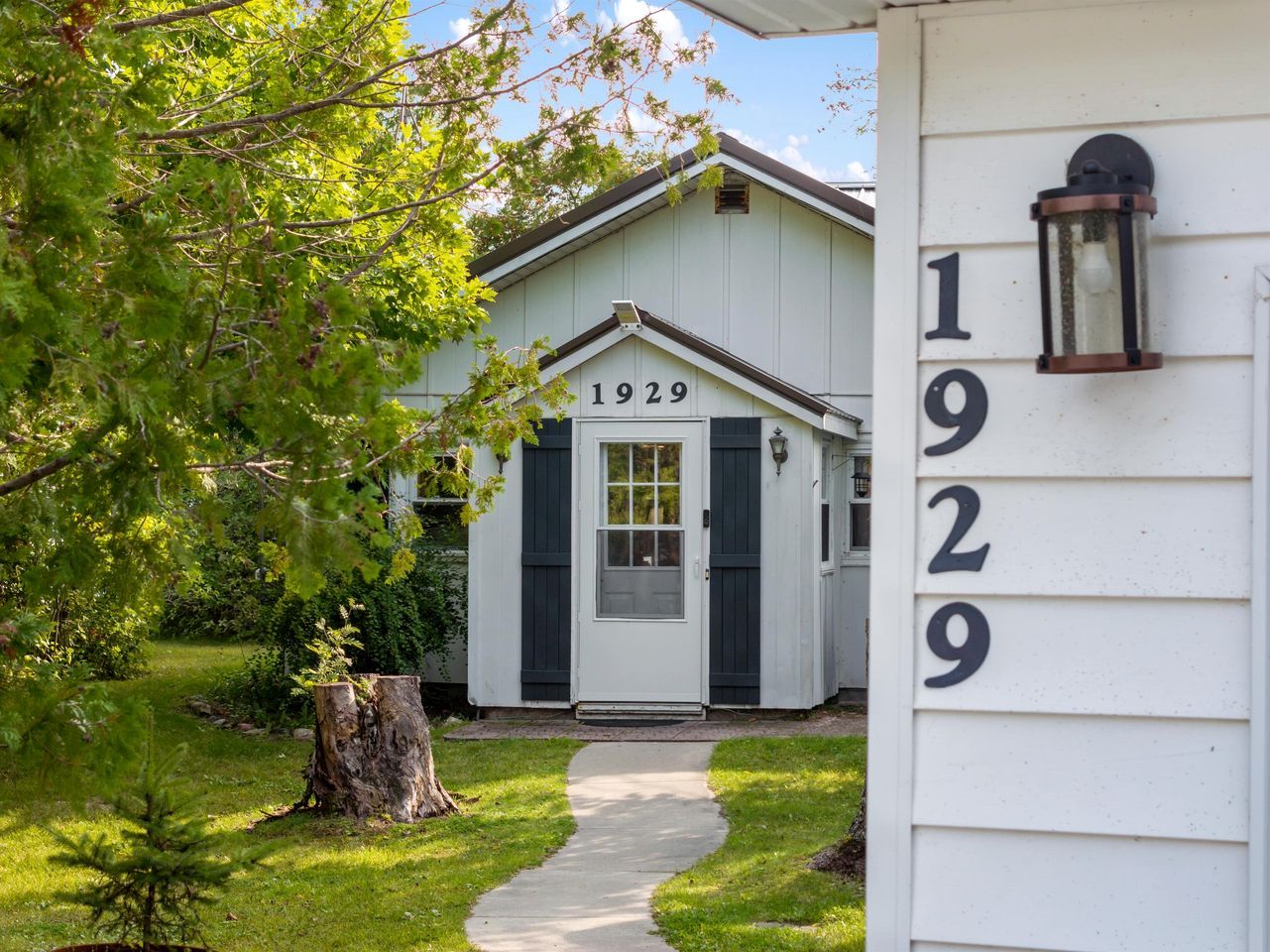 A white building with the number 1929, a front door, and a small porch.