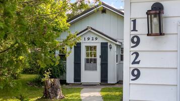 A white building with the number 1929, a front door, and a small porch.