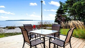 A deck with a table and chairs overlooking a body of water. - Fantastic Lakefront Beach House with Stunning Views in St. Ignace, Michigan (St. Ignace)