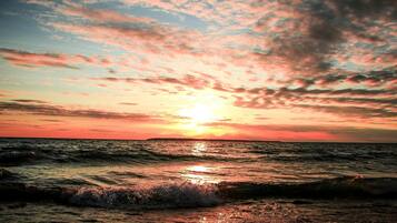 A sunset over the ocean with waves.