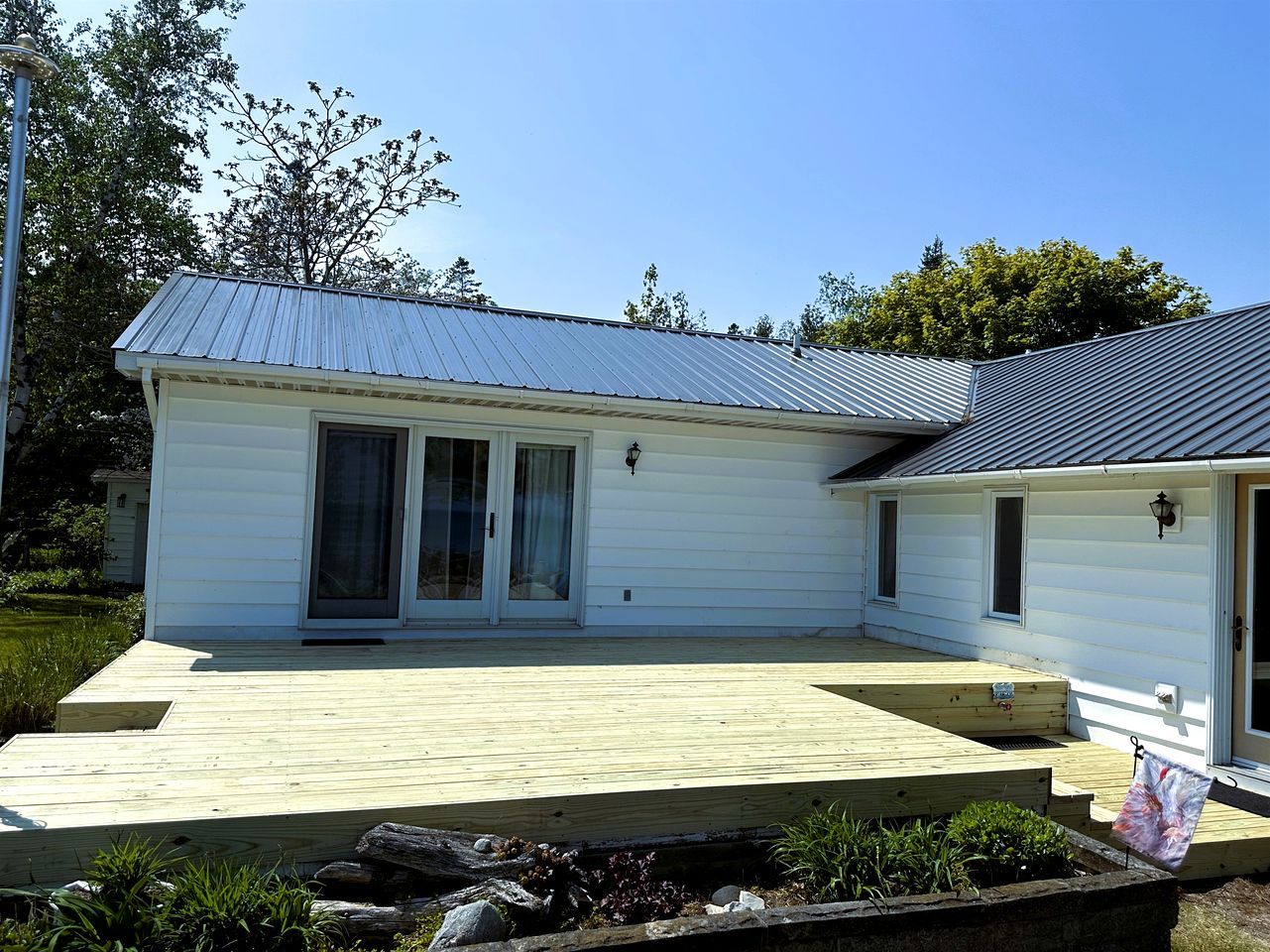 A single-story house with a covered porch, a sliding glass door, and a small attached garage.