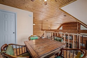 Ein Holzespeisesaal mit Stühlen, einer Treppe und einem Kamin.